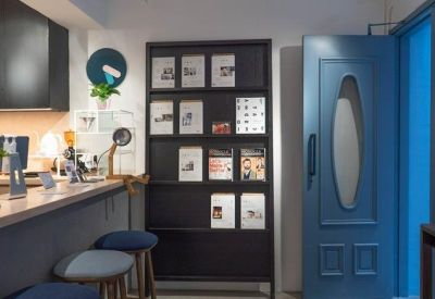 Lounge area featuring a blue door, book display, and a bar counter with stools.