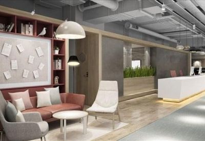 Spacious reception area with a long white desk, warm wooden accents, and a comfortable seating lounge.