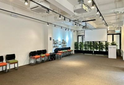 Large multi-purpose seminar room with a projector screen and rows of colorful seating.