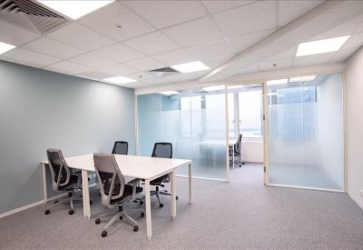 Four-person private office suite with white desks and frosted glass partitions.