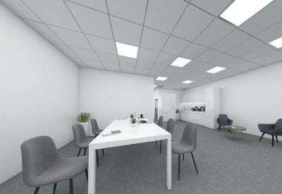 Bright conference room with a long white table and several grey chairs.