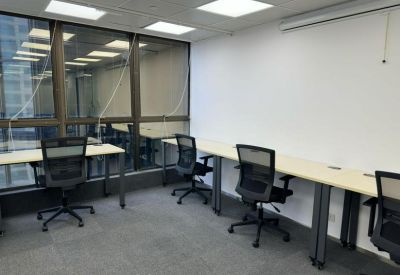 Shared office space featuring multiple workstations along a wall with task chairs.