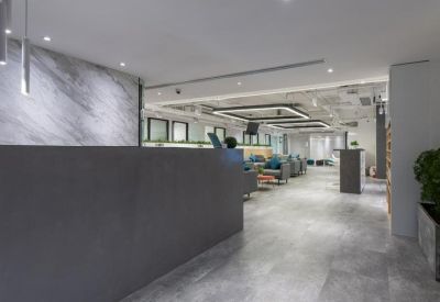Modern reception lobby featuring a dark stone desk and marble-patterned feature wall.