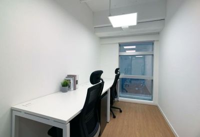 Internal two-person private office suite with white desks and ergonomic black chairs.