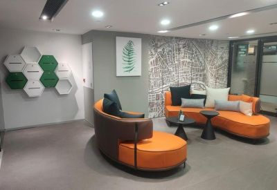 Reception or lounge area with a designer orange sofa and a stylized map wall mural.