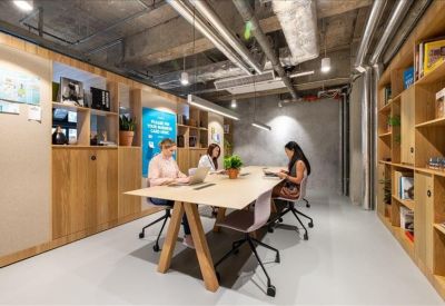 Industrial-style coworking space with wooden cabinetry and a long communal desk.