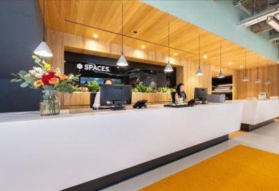 Modern reception desk with wooden wall paneling and fresh floral arrangements.