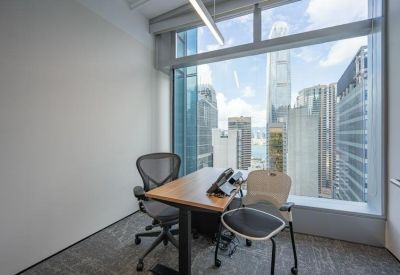 Private window office with a wooden desk and views of the city skyline.