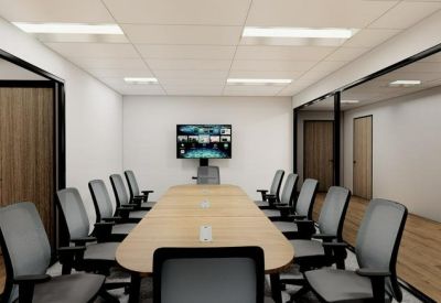 Professional boardroom with a long wooden table and video conferencing screen.