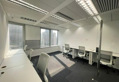 Private office space featuring white desks, grey chairs, and a city view window.