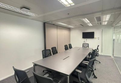Large professional meeting room with a dark grey table and mesh office chairs.