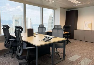 Internal office suite with light wood desks, ergonomic chairs, and panoramic window views.
