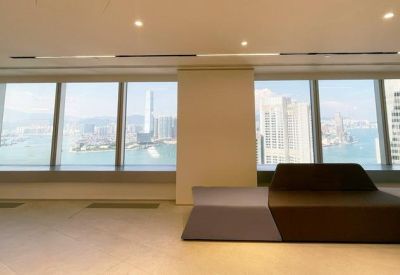 Modern lounge area with a minimalist block sofa facing large windows overlooking Victoria Harbour.