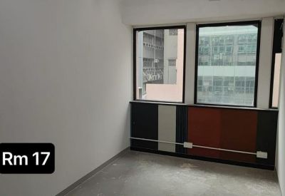 Small private office with large windows and colorful wood paneling under the sill.