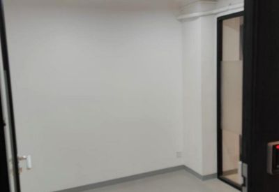 Bright, empty internal office suite with modern strip lighting and grey flooring.
