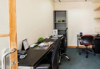 Private office space featuring a long dark desk and shelving unit.