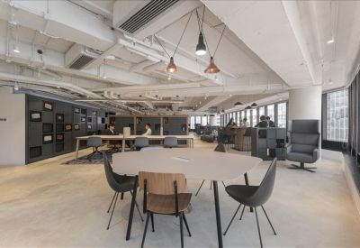 Spacious communal lounge area with a variety of seating and industrial ceiling.