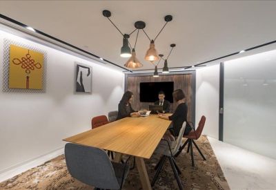 Six-person meeting room with vibrant wall art and a large wooden table.