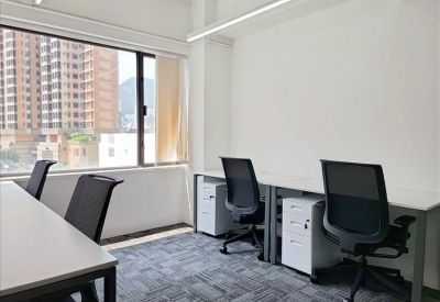 Private office suite with two desks and large windows overlooking the city.