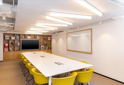 Meeting room at 8 Queen’s Road East with a large white table and vibrant yellow chairs.
