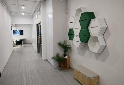 Hallway featuring a unique hexagonal locker wall in white and green tones.