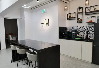 Communal break area with a kitchen island, bar stools, and modern cabinetry.