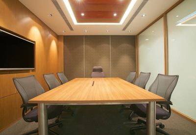 Professional boardroom with a long wooden table, leather chairs, and integrated lighting.