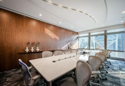 Executive meeting room with a large white table and wood-paneled feature wall.