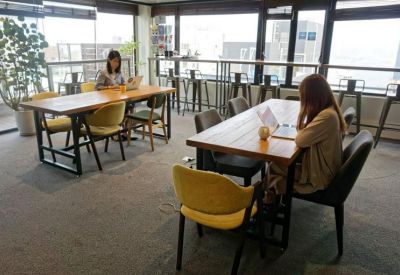 Open-plan work area featuring individual laptop stations and ample natural light.