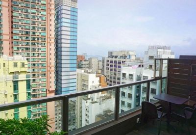 Balcony view of the dense urban skyline and nearby high-rise buildings.
