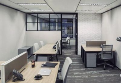 Modern private office suite with multiple workstations and glass partitions.