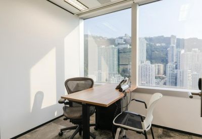 Private window office with a wooden desk and views of the surrounding skyscrapers.