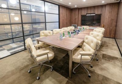 Professional meeting room featuring cream leather chairs and a glass partition wall.