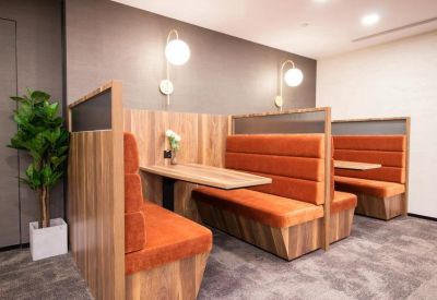 Quiet breakout area featuring private booths with orange padded seating.