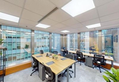 Bright corner office with six desks and floor-to-ceiling windows.