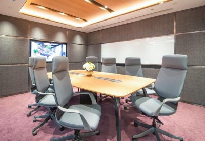 Modern boardroom with grey ergonomic chairs and a large wooden table.