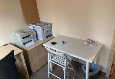 Compact private office with two light wood desks and a printer.