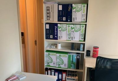 Internal office space featuring a tall white shelving unit filled with supplies.