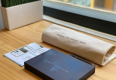Branded welcome materials and a notebook on a light wood tabletop.
