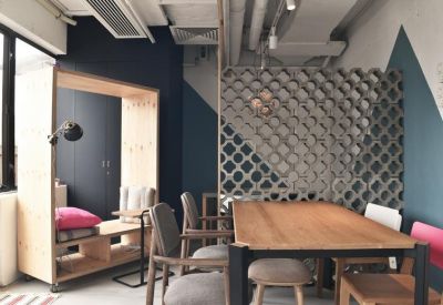 Meeting area featuring a large wooden table and a unique decorative lattice wall divider.