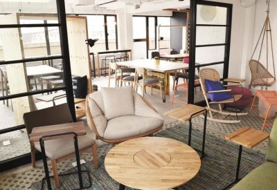 Relaxed lounge area with a round wooden table, rocking chairs, and natural light.
