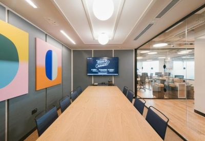 Professional meeting room with a long light-wood table and blue chairs.
