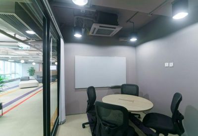 Small private meeting room with a round table, four black chairs, and a whiteboard.
