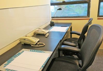 Two-person shared office suite with dual desks and a whiteboard.