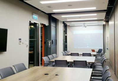 Modern café-style breakout space with a high bar counter, stools, and designer lighting.
