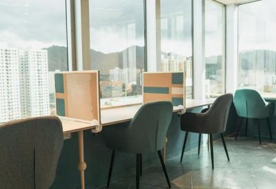 Individual window-facing workstations with privacy dividers and views of the surrounding urban mountains.