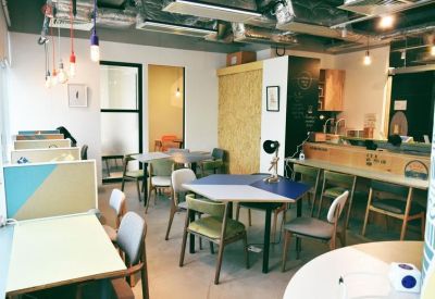 Bright coworking space with colourful chairs and multi-functional geometric tables.