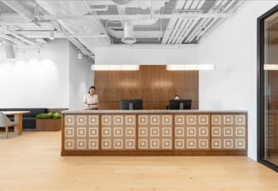 Modern reception desk featuring a geometric pattern and warm wood paneling.