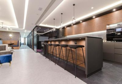 Modern café area with a dark wood breakfast bar, high stools, and warm pendant lighting.