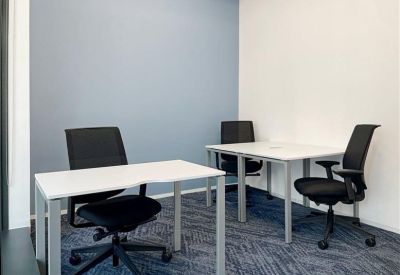 Two-person private office suite with white desks and ergonomic black chairs.
